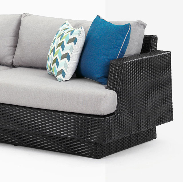 dark wicker outdoor patio sofa with colored cushions 